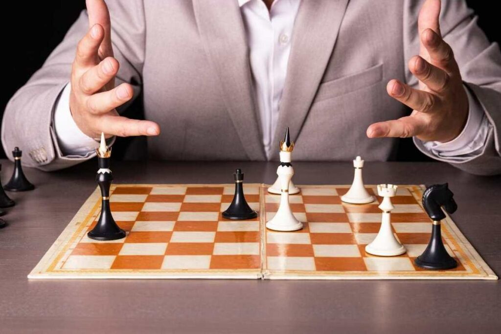 man's hands looking at moves on a chess board