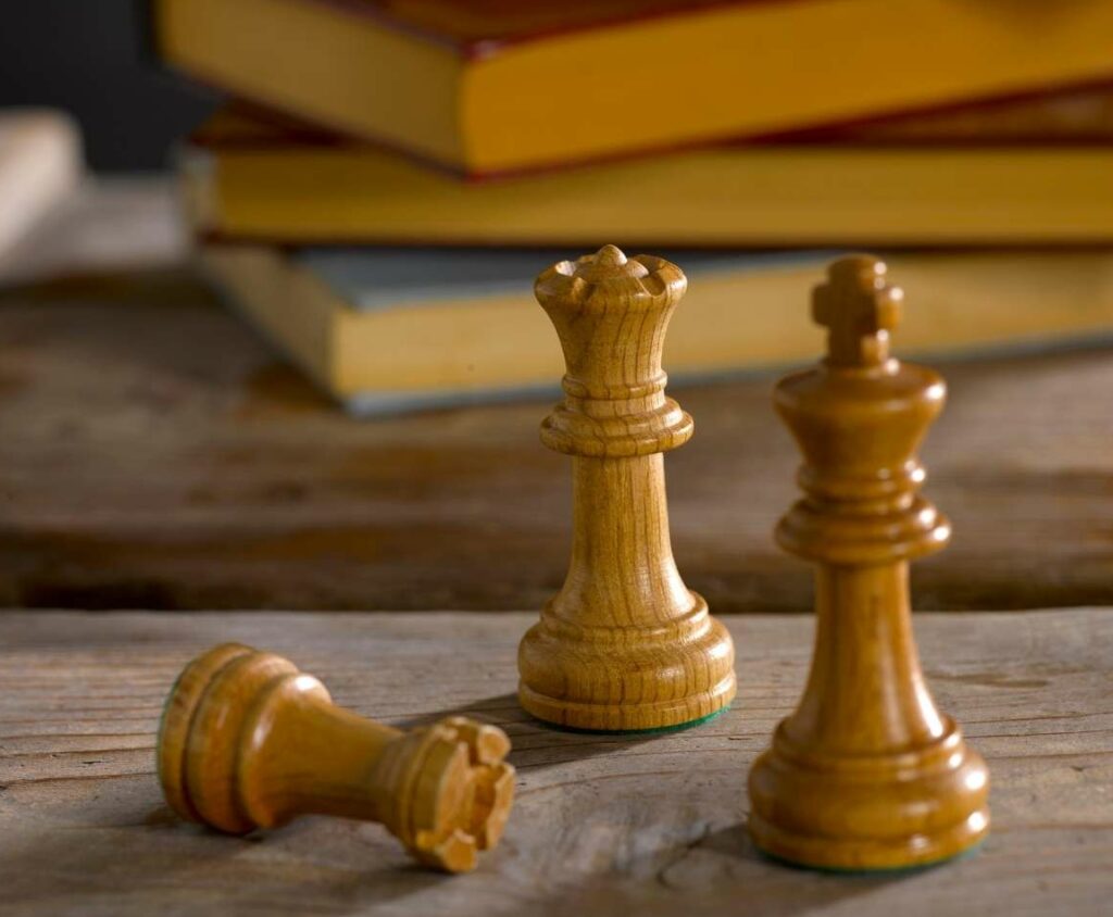 wooden chess pieces and old rule books