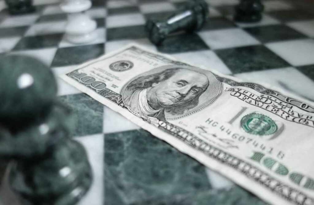 chess pieces and a $100 bill