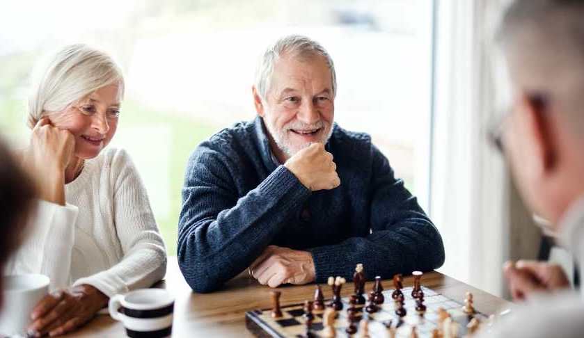 Older people interacting and playing chess together